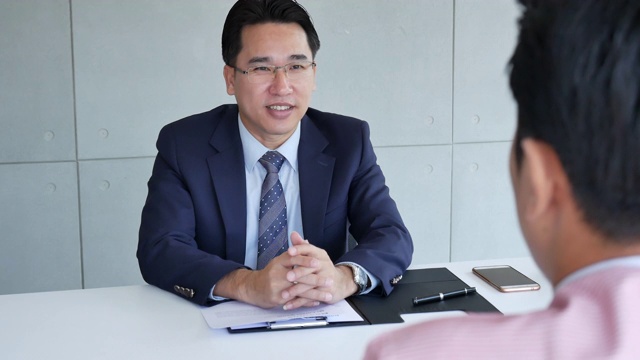 工作人力资源申请人有一个面试与人力资源经理的工作面试与自信的候选人在商业公司办公室给简历。与猎头公司和申请人进行面试