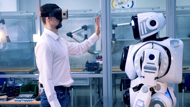 詳情圖-一名戴著VR眼鏡的男子與機器人擊掌。