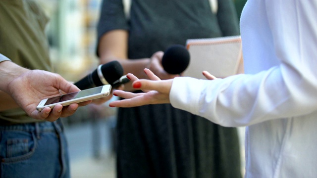 女子在接受媒体采访、新闻发布会、特写时打手势