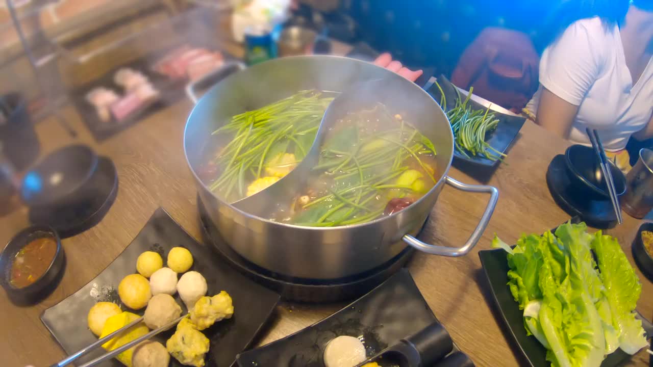 一群亚洲青少年在台湾购物中心吃涮锅的场景，城市里人们的生活方式的概念