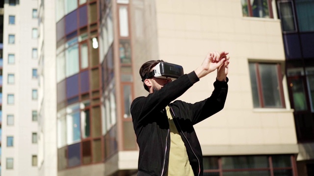 詳情圖-用慢鏡頭平移年輕男子戴著vr眼鏡站在城市街道的戶外，與虛擬現(xiàn)實(shí)中可視化的數(shù)據(jù)和信息一起工作