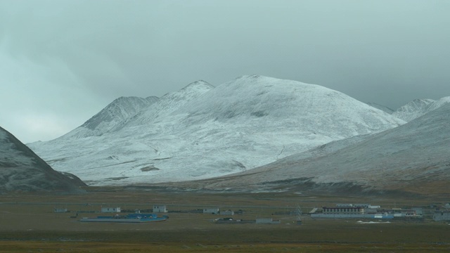 慢镜头:乘坐夜间火车经过雪山下的一个村庄。