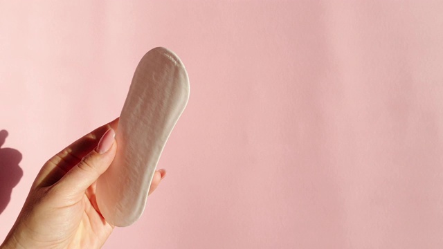 粉色背景上的女性私密卫生用品
