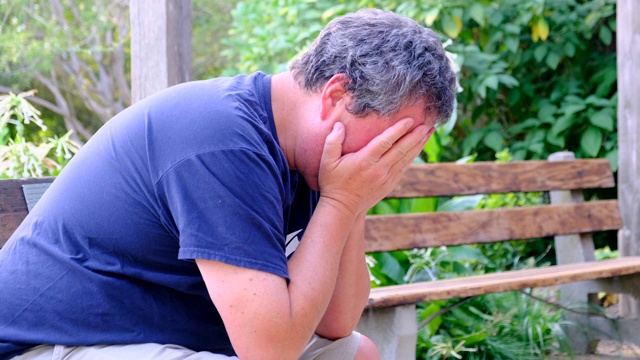 绝望的成熟男人用双手捧着他的头