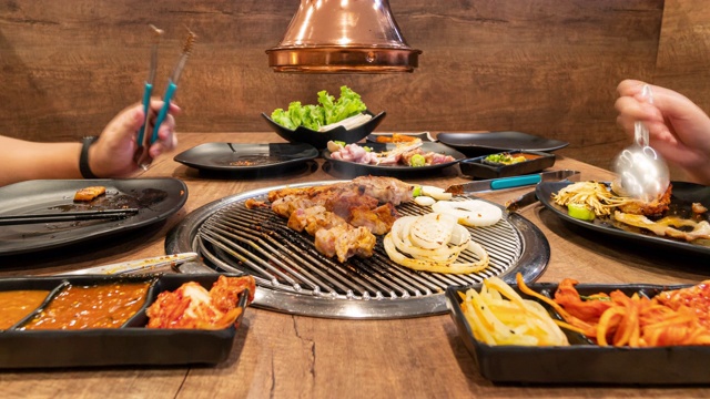 时间流逝:亚洲人在韩国餐厅烧烤。食品的概念
