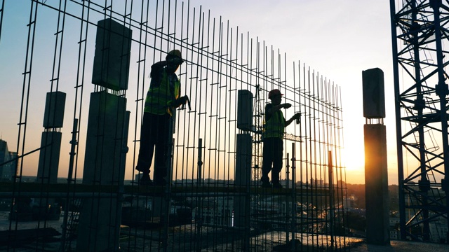 夕陽建筑工地，工程師在制作金屬骨架