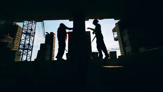 詳情圖-背光建筑工人正在建造一堵墻