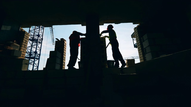 詳情圖-背光建筑工人正在建造一堵墻