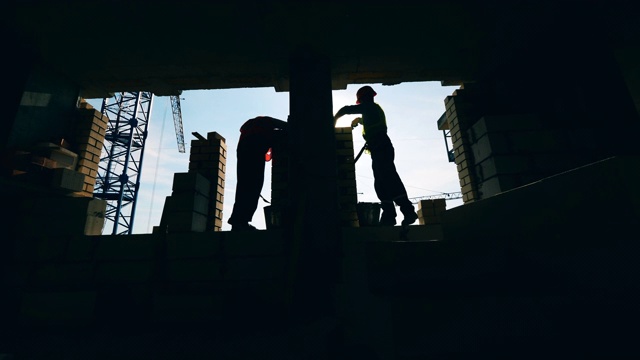 詳情圖-背光建筑工人正在建造一堵墻