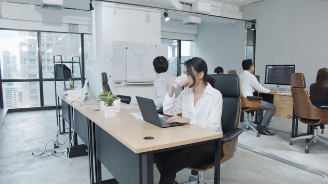 详情图-4K超高清:亚洲女员工在现代办公背景下使用笔记本电脑工作。