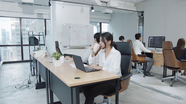 详情图-4K超高清:亚洲女员工在现代办公背景下使用笔记本电脑工作。
