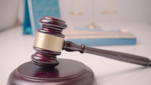 桌子上放着一把木槌，旁边放着一份商业研究文件。法律和商业行为排队