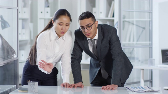 亚洲女人和阿拉伯男人看不见的AR触摸屏在办公室