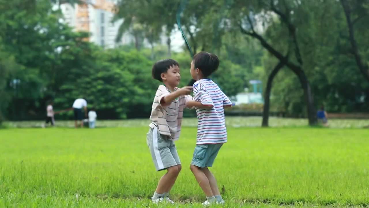 小男孩在草地上跳绳
