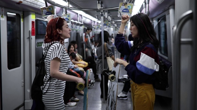 在地铁里玩滑板的女孩