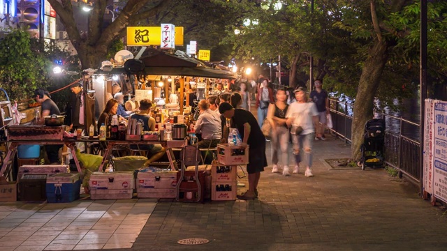 时光流逝:游客聚集在日本福冈博多中河八台小吃摊