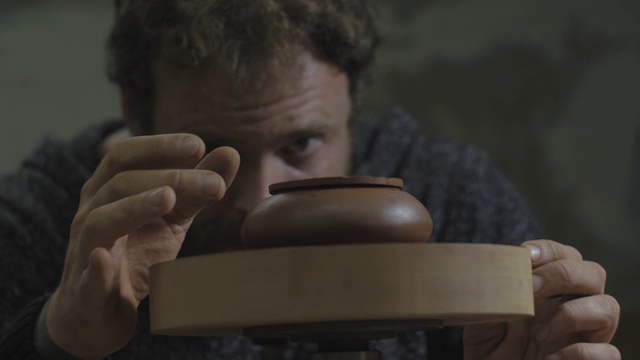 詳情圖-一名工匠將宜興陶土茶壺放在木軸上旋轉(zhuǎn)。宜興茶道手工陶壺。褐色陶器茶壺。4,k的視頻。59.94幀/秒