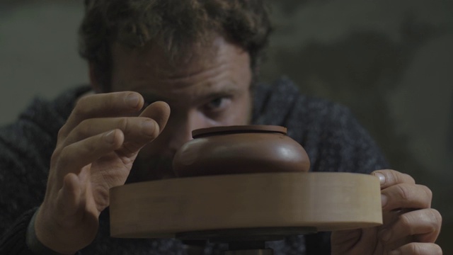 詳情圖-一名工匠將宜興陶土茶壺放在木軸上旋轉(zhuǎn)。宜興茶道手工陶壺。褐色陶器茶壺。4,k的視頻。59.94幀/秒