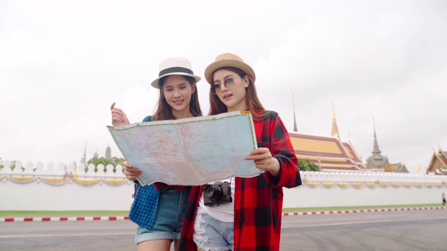 女人和朋友在看地图。亚洲女人享受在泰国唐人街旅游