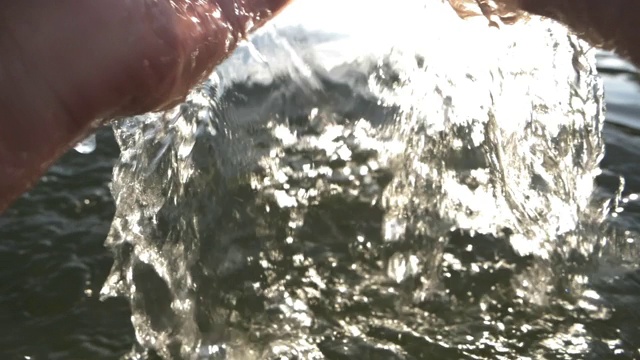 男性用手从湖中舀水