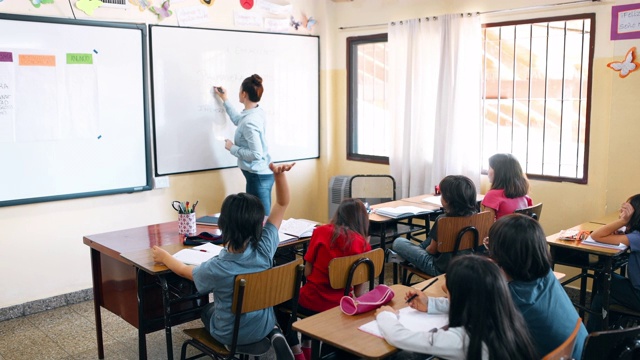 小学教师与学生在教室里工作