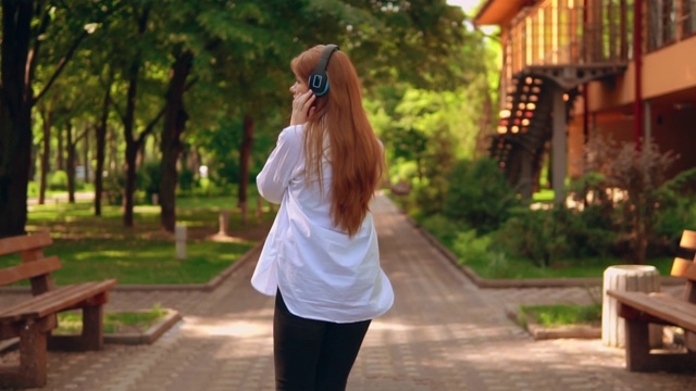 戴着耳机的陌生女性在公园里漫步