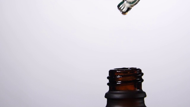 详情图-慢动作的液滴从移液管中以正确的成分滴入瓶中