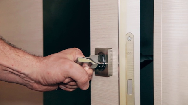 一个男人的手打开和关闭钢质金属门HD 1920x1080。