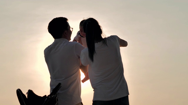 详情图-快乐的亚洲父亲，母亲和婴儿儿子愉快与乐趣沿海边的日落海浪在沙滩上。积极的父母和人在暑假与孩子户外活动。幸福的家庭假期。家庭、生活方式、人、人寿保险、假期
