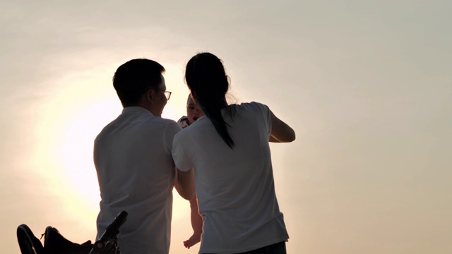 详情图-快乐的亚洲父亲，母亲和婴儿儿子愉快与乐趣沿海边的日落海浪在沙滩上。积极的父母和人在暑假与孩子户外活动。幸福的家庭假期。家庭、生活方式、人、人寿保险、假期
