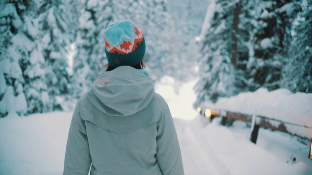 亚洲女人行走在白雪覆盖的森林里