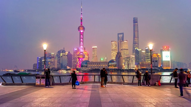 中国上海，人们在以城市天际线为背景的外滩漫步的时间。