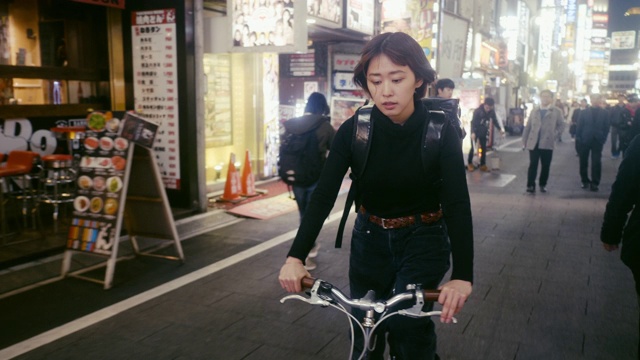 日本女食品快递员在东京寻找送货地址(慢镜头)