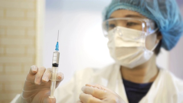 详情图-中国女外科医生检查医用注射器。