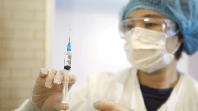 详情图-中国女外科医生检查医用注射器。