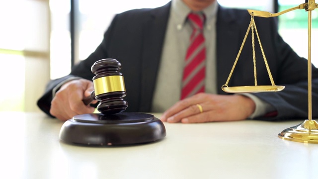 一段男性律师在律师办公室拿着小木槌的4K视频