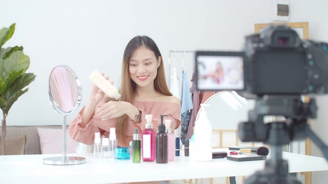 美丽的亚洲女人博客展示如何化妆和使用化妆品。在摄像机前录制在家的视频直播。商业在线影响者对社交媒体的概念。