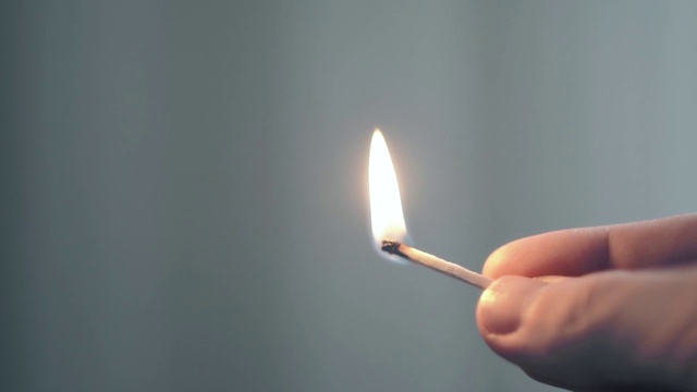 慢镜头，一个人点燃一根火柴，闪光
