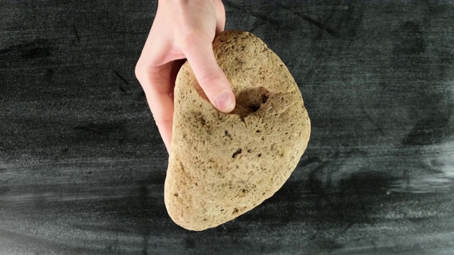 男手拿着大石头。前视图。