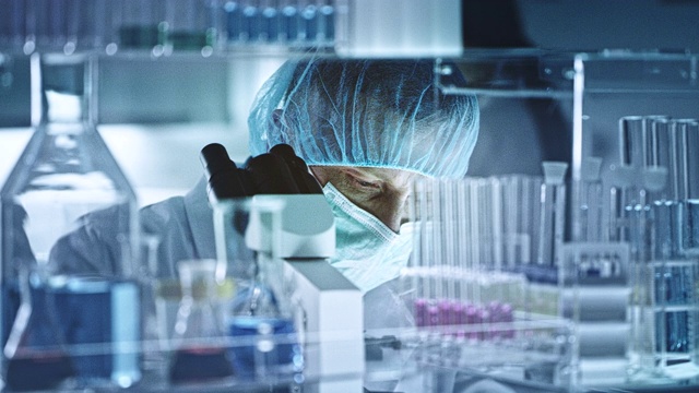 人类正在通过显微镜观察