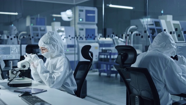 详情图-研究工厂洁净室:工程师和科学家团队在电脑上工作，使用显微镜检查主板微处理器，为医疗电子开发电子