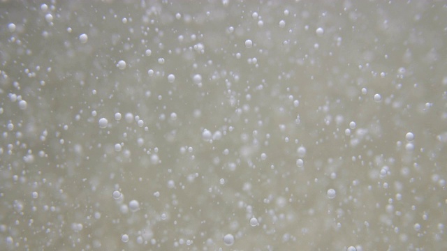 白色液体的慢动作气泡在透明液体中缓慢移动