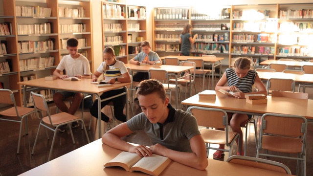 男女学生在学校图书馆里准备上课