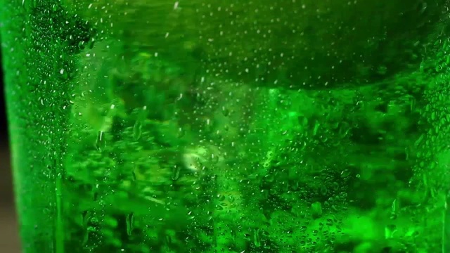 详情图-冰冷的冰块漂浮在绿色的泡沫鸡尾酒中旋转。