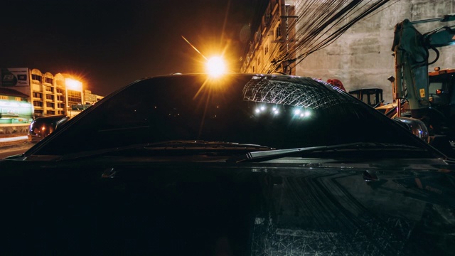 一辆黑色汽车在夜间行驶在道路上