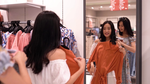 亚洲华人女性在服装零售店购物和浏览