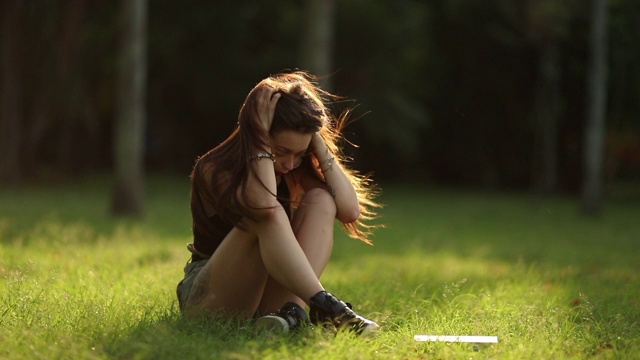 悲伤沮丧的女孩。孤独的女人独自坐在公园外面心烦意乱，女士有烦恼，焦虑和压力