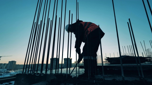 建筑工地的建筑工人。建筑工地和一名建筑工人正在打碎混凝土