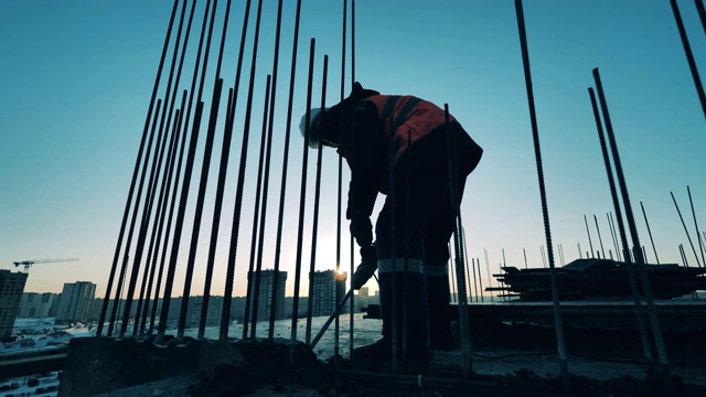 詳情圖-建筑工地的建筑工人。建筑工地和一名建筑工人正在打碎混凝土