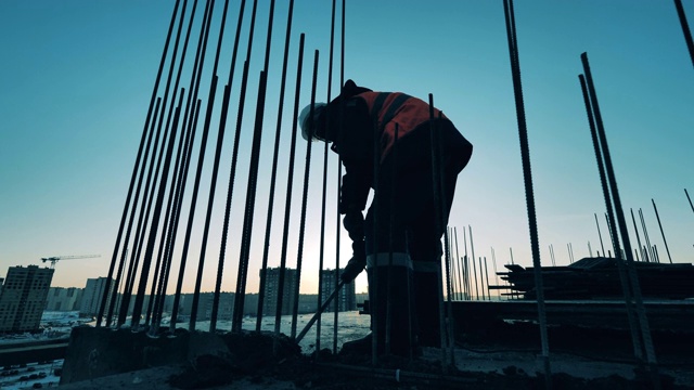 詳情圖-建筑工地的建筑工人。建筑工地和一名建筑工人正在打碎混凝土